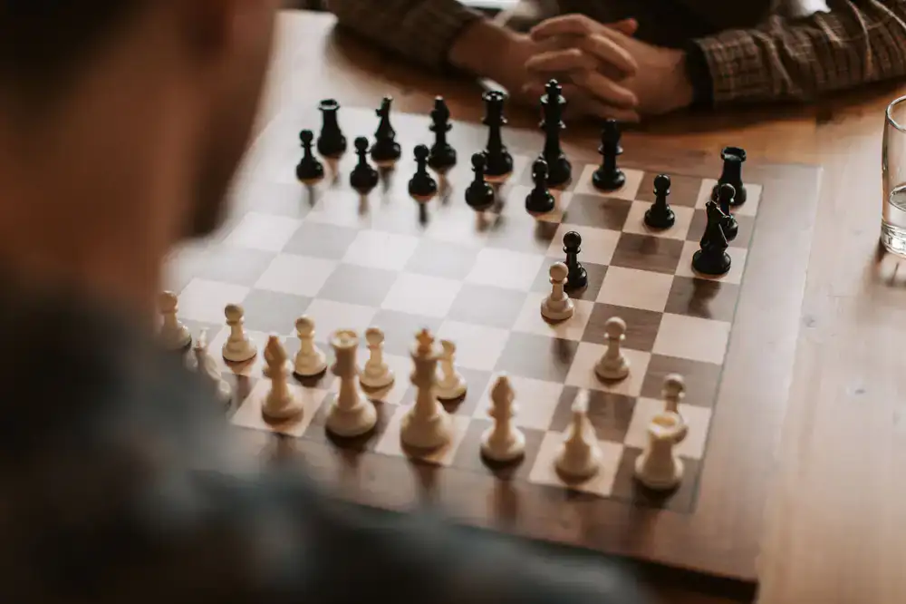 Two people enjoying coffee and pastries over a board game