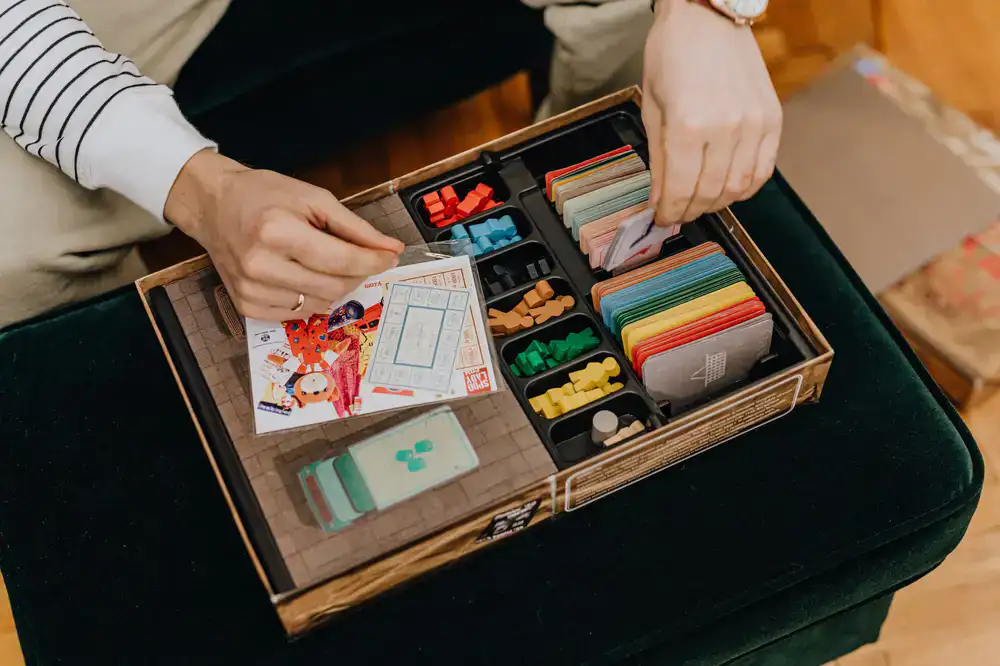 A friendly staff member pointing at a game board, explaining rules to seated guests